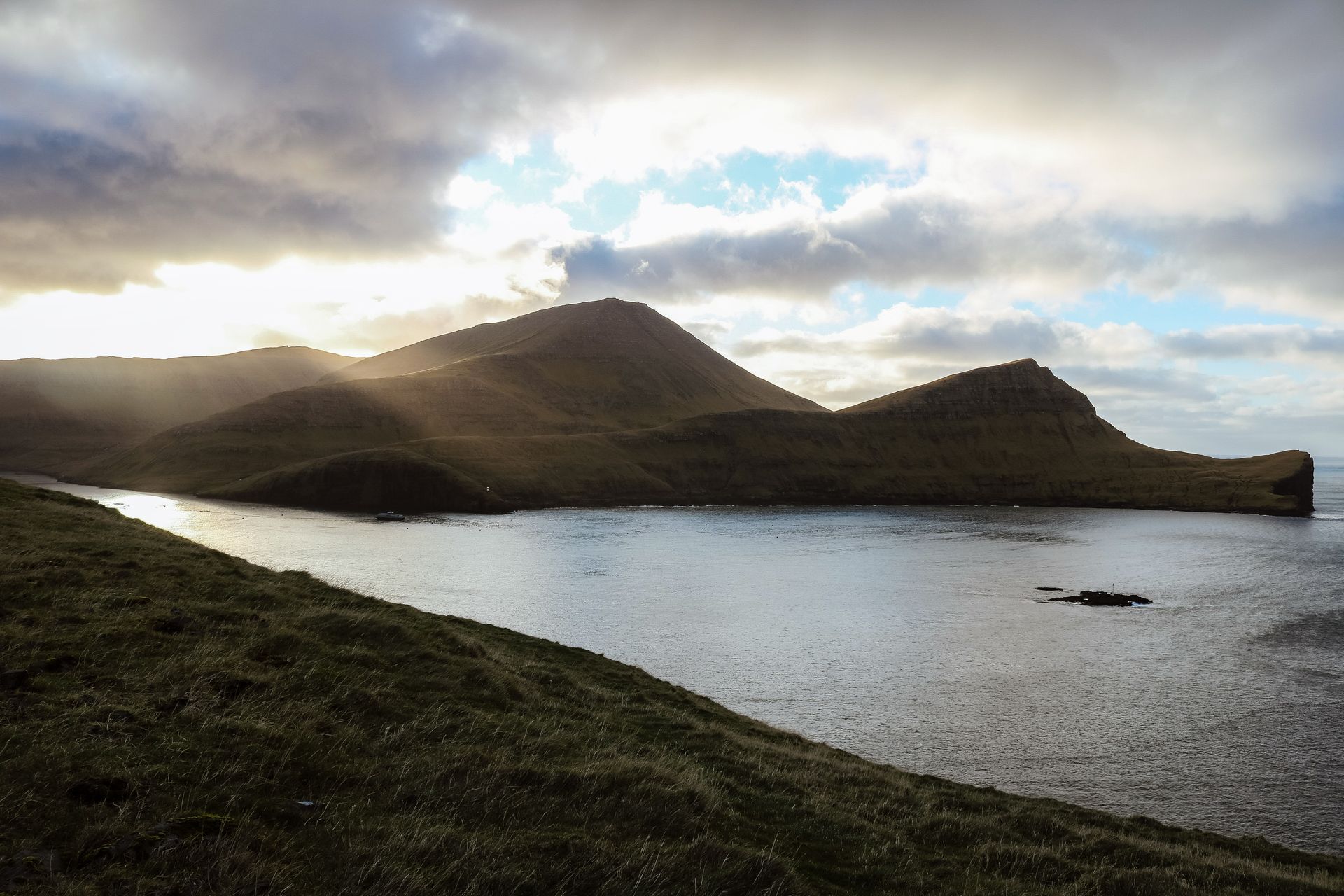 Faroese headlands catching the last of the sun above a dark fjord