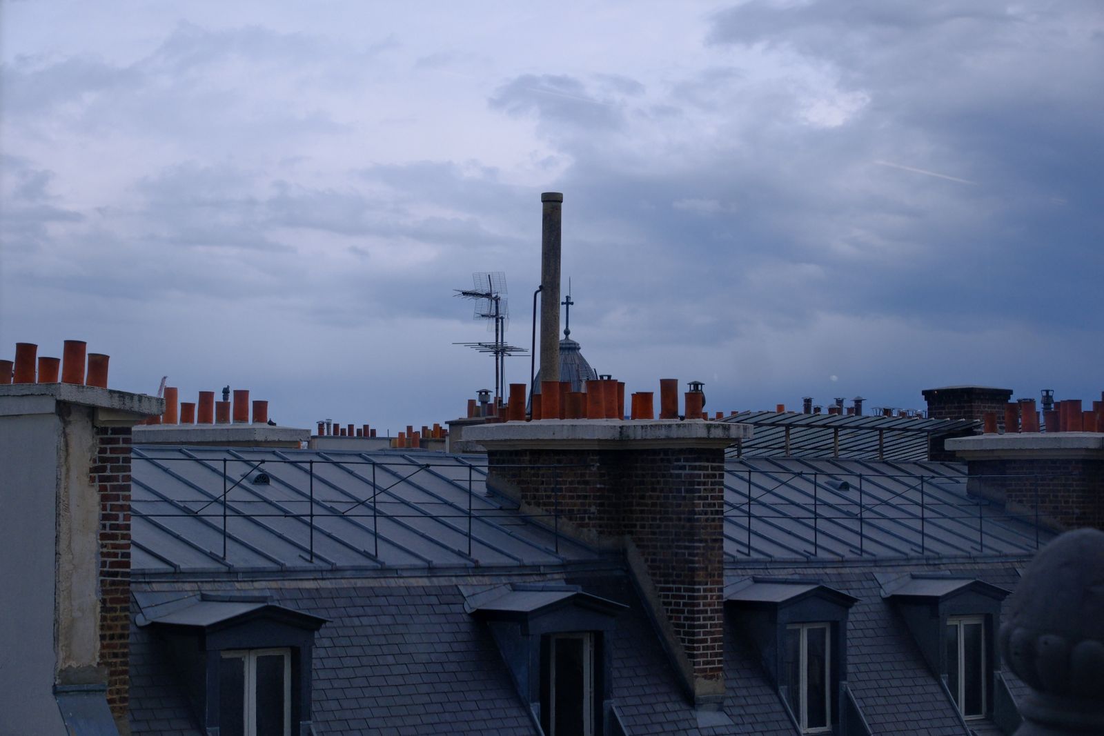 Parisian rooftops and chimneys turning violet at dusk