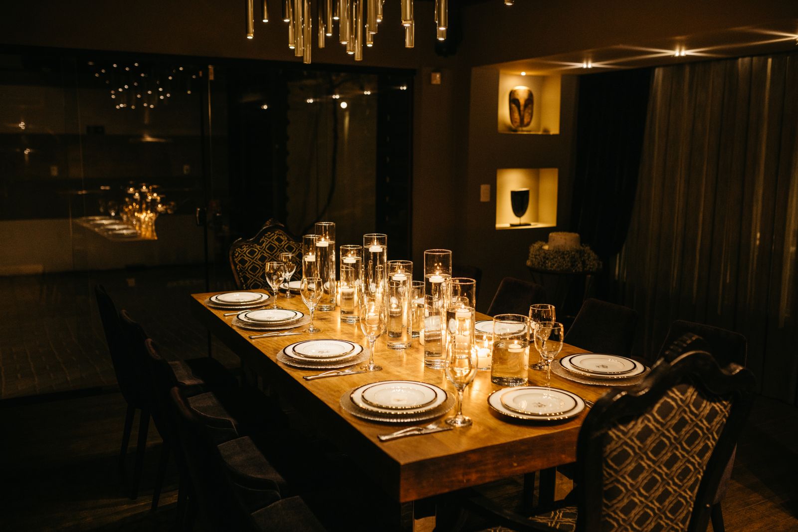 A candlelit table laid in a small, dark dining room