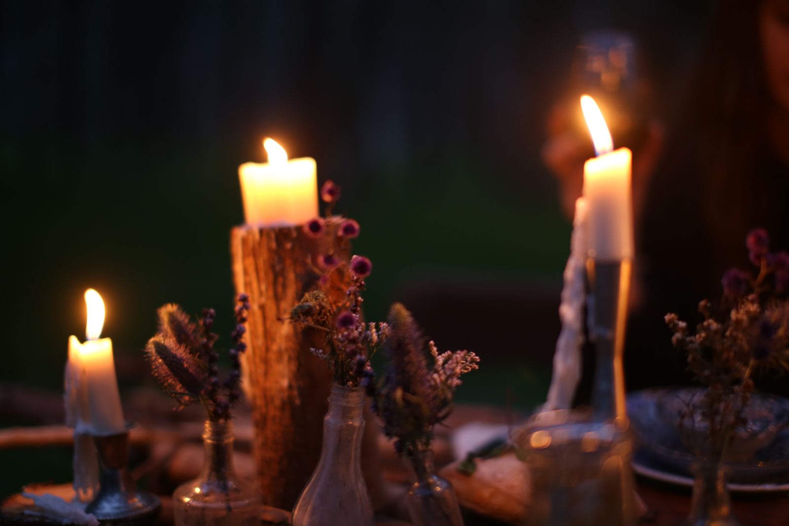 A long table set with candles in the evening
