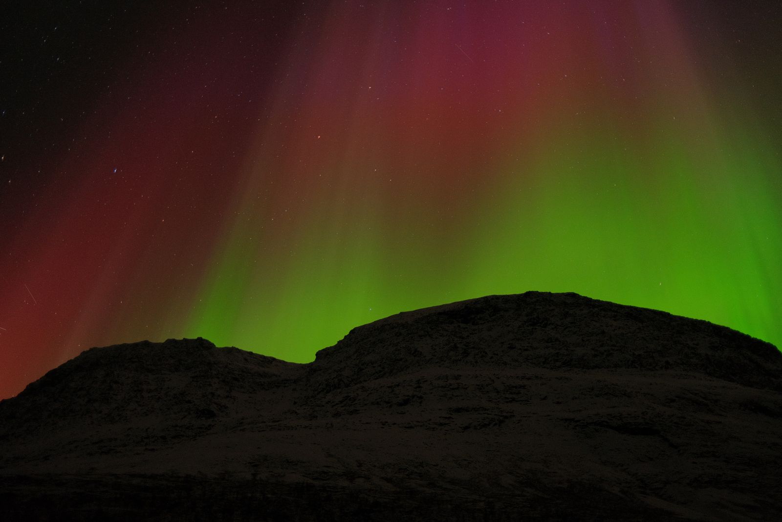 The northern lights curling over a snowbound Arctic landscape