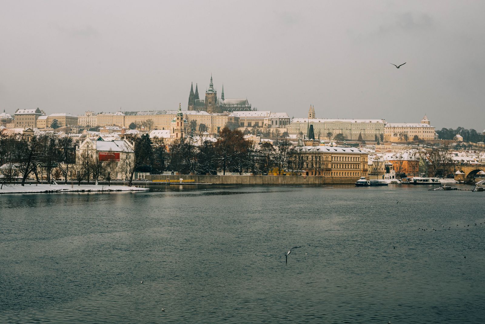 Prague castle and its spires seen across the winter river
