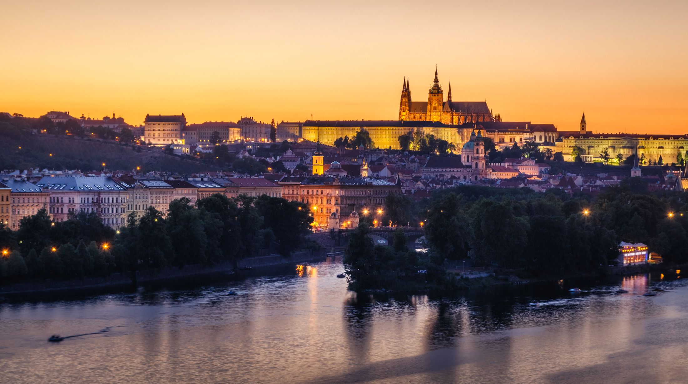 Prague's hundred spires and its castle glowing over the Vltava at sunset